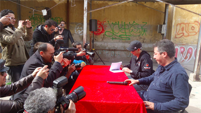 [Mouad Belghouat, also known as El Haqed, gives a press conference in Casablanca following his release from prison. Image via Dire Li Bghiti Facebook Page.]