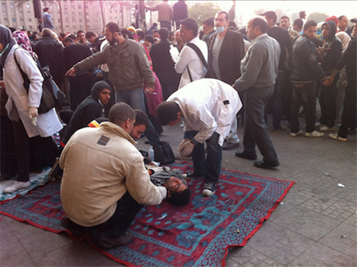 [21 November 2011, an injured protesters receiving first aid following clashes with the security forces, Cairo, Egypt. Image originally posted to Flickr by Al Jazeerah English]