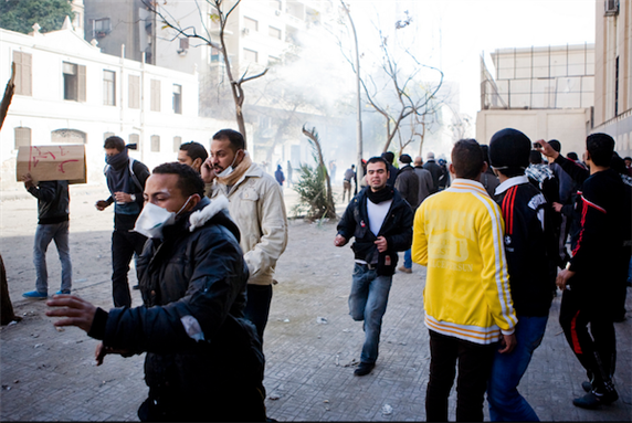 [3 February 2012, protesters escaping round of tear gas fired at them by central security forces on Mansour St., Cairo, Egypt. Image originally posted to Flickr by Hossam El-Hamlawi