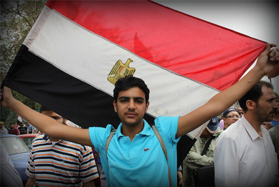[20 April 2012, protester carrying the Egyptian flag. Image originally posted to Flickr by Gigi Ibrahim]
