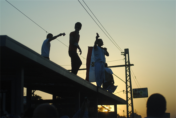 [Protesters cheering the helicopters (not shown in photo) flying over the crowds on 28 June 2013, Cairo, Egypt. Image originally posted to Flickr by Lilian Wagdy]