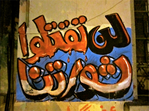 [Graffiti in Arabic reads: \"You will not kill our revolution.\" Image originally posted to Flickr by Gigi Ibrahim.]
