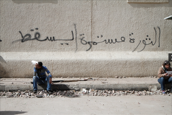 [21 February 2012, graffiti in Arabic reads: \"The revolution continues.\" Image originally posted to Flickr by Sarah Carr.]