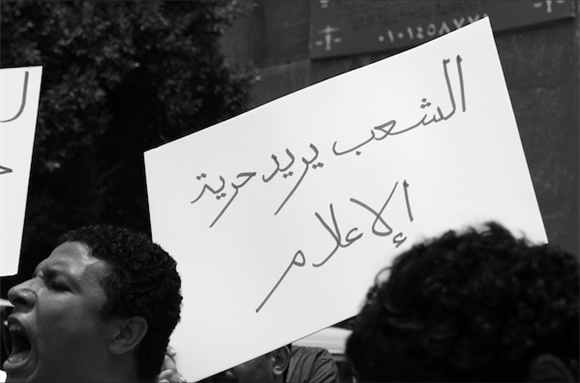 [19 June 2011, a protest in solidarity with journalist Rasha Azab who was summoned by the military for questioning following a piece she wrote about military violations against protestors and military trials of civilians. The Arabic reads: \"The people demand a free media.\" Caption and photo courtesy of Nora Shalaby via Flickr.]