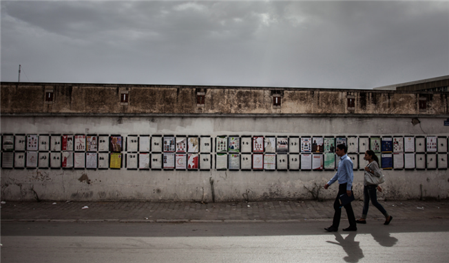 [Image of candidate posters on a wall in Tunisia. Image by Malek Khadraoui for Heinrich-Böll-Stiftung/Flickr]