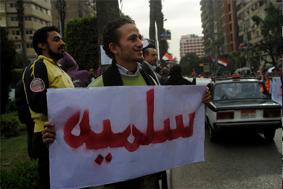 [10 February 2012, protest heading to Ministry of Defense. The Arabic reads: \"Peaceful.\" Photo by Lilian Wagdy via Flick] 