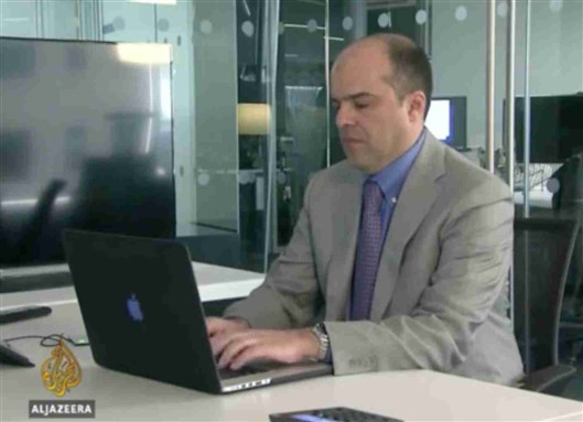 [Jadaliyya Co-Editor Mouin Rabbani in Al-Jazeera English Office. Image from screenshot of below video]