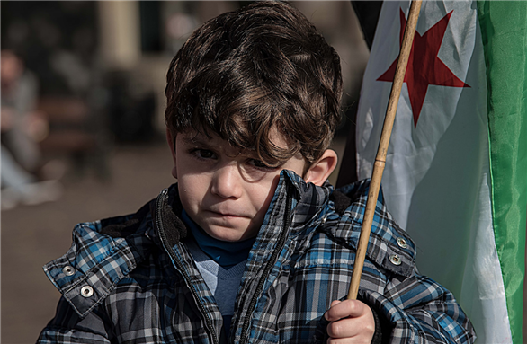[Image of a Syrian boy at a \"Stop Bombing Syria\" demonstration. Image by Geert Smits via Flickr]