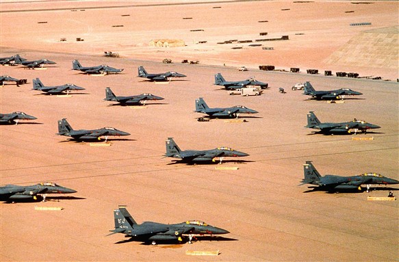 [US Air Force F-15E Eagle fighter aircraft of the 4th Tactical Fighter Wing, Seymour Johnson Air Force Base, N.C., are parked on an air field during Operation Desert Shield. Image by Phan Chad Vann via Wikimedia Common]