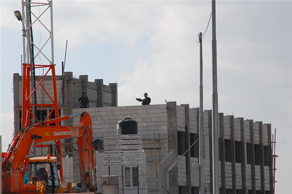 [Illegal Settlement Construction in Nilin. Israeli army occupying building and shooting at demonstrators.: taken by ISM Palestine and uploaded from Wikimedia Commons]