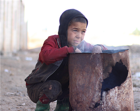 [Image of a displaced Syrian child, Ahmed, trying to keep warm. Image via The United Nations Children`s Fund via Flickr]
