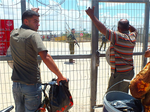 [These people wait in groups of five for the Israeli soldiers to get them through the “agricultural passage” in the Qalqilya-envelope fence, opening 1pm sharp, and would be bound to return on the same day when the gate operates again, some 4 hours later. Scarce few are granted an overnight pass. Photo taken by Orrling and uploaded from Wikimedia Commons]