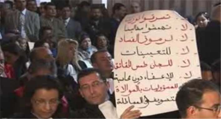 [Image of Tunisian judge holding list of demands for judicial independence. Image from Presstv.ir]
