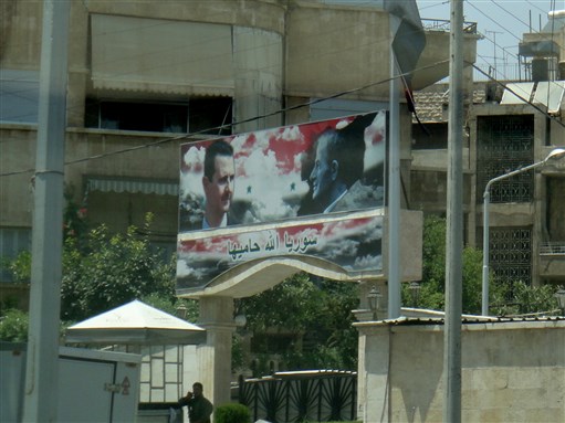 [Assad, Father and Son, Billboard with \"God Protect Syria.\" Image by Amal Hanano]