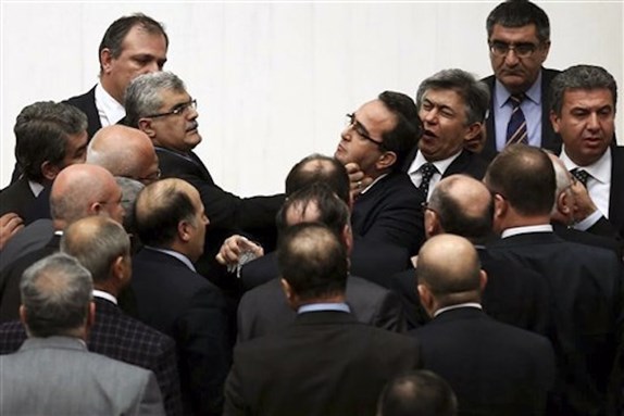 [Turkish legislators from the AKP and the CHP brawl during a tense all-night debate over a controversial law on changes to a council that appoints and overseas judges and prosecutors, in Ankara, 15 February. One legislator suffered a broken finger while another suffered a nose-bleed. Opposition parties say the bill would give the government wider controls over the council. (Unidentified Photographer/AP Photo)]