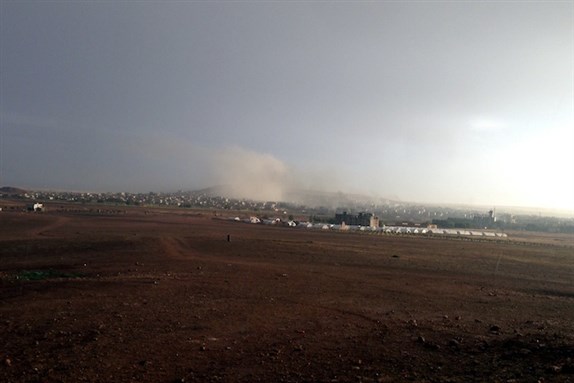 [A view of Kobanê during the bombardment of ISIL targets by US-led forces. Photo by M. Akhavan / Persian Dutch Network, via Wikimedia Commons.]