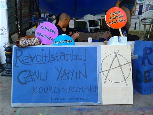 [Table and signs at Gezi Park, Taksim Square, on 9 June 2013. Image by Carole Woodall.]