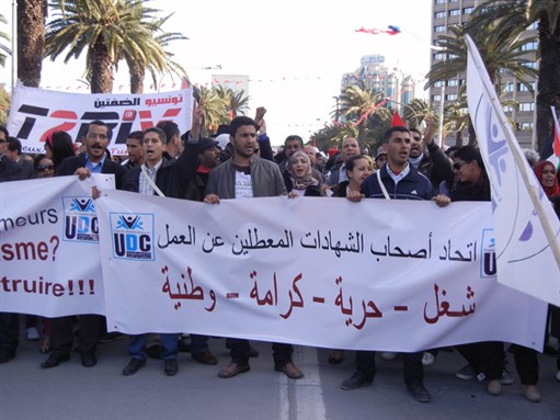 [Unemployed diploma holders carry a banner reading “work, freedom, dignity, nationalism” at the 2013 World Social Forum in Tunis. Image by Frances Hasso]