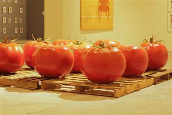 [Yasmine Elmeleegy sculpted giant tomatoes to comment on the use of genetic engineering in agricultural production. Image courtesy of MedrarTV.]