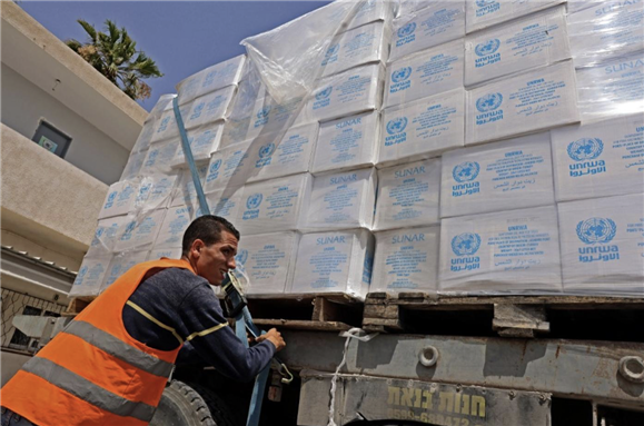 A truck loaded with humanitarian aid passes into the southern Gaza Strip through the Kerem Shalom crossing, the main passage point for goods entering Gaza from Israel, on 21 May 2021 (AFP)