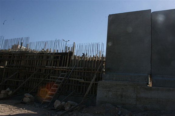 [Portion of Israel`s separation wall, under construction. Photo by ISM Palestine. From Wikimedia Commons.]