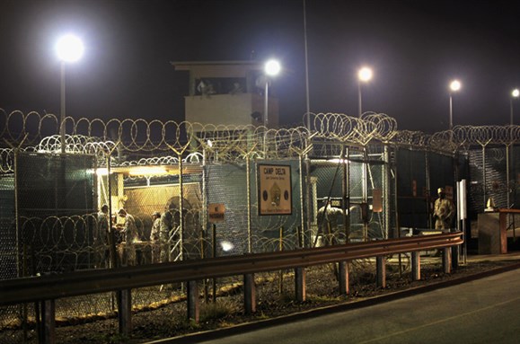 [First prisoners arrive at Guantanamo on 11 January 2002. Image from Gallo/Getty]