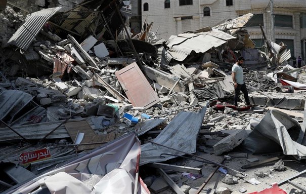 A man inspects the rubble of destroyed residential building which was hit by Israeli airstrikes, in Gaza City, Thursday, May 20, 2021 via AP from Adel Hana