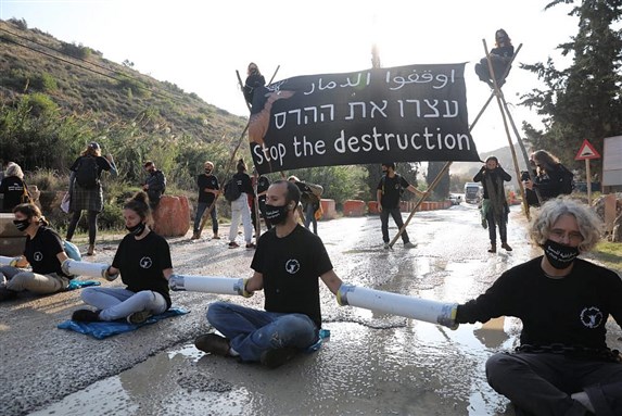 Israeli climate and human rights activists chain themselves to the entrance of HeidelbergCement quarry in the occupied West Bank to protest a government plan to expand the quarry and build an industrial zone nearby, November 22, 2020. (Oren Ziv) via +972 Magazine