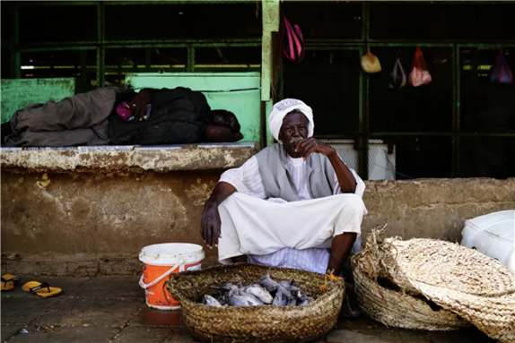 A Sudanese vendor sells fish at a market in Khartoum on June 17, 2019 [Umit Bektas/Reuters]