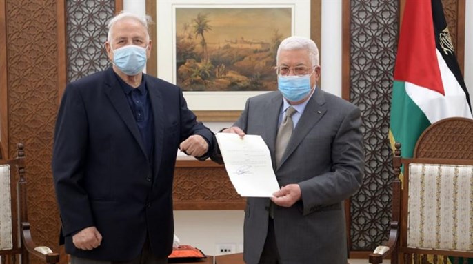 Palestinian President Mahmoud Abbas hands the election decree to Chairman of the Palestinian Central Election Committee Hana Naser in Ramallah in the West Bank January 15, 2021 via Reuters