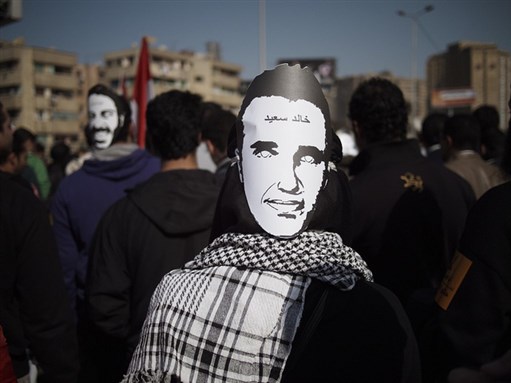 [Protester wearing a mask showing the face of the martyr Khaled Said. 25 January 2012. Photo by Mostafa Hussein]