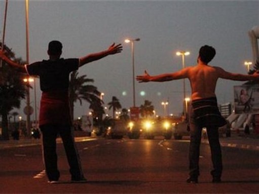 [Young men facing bullets in Bahrain. Image from sites.duke.edu/genderarabrev/]