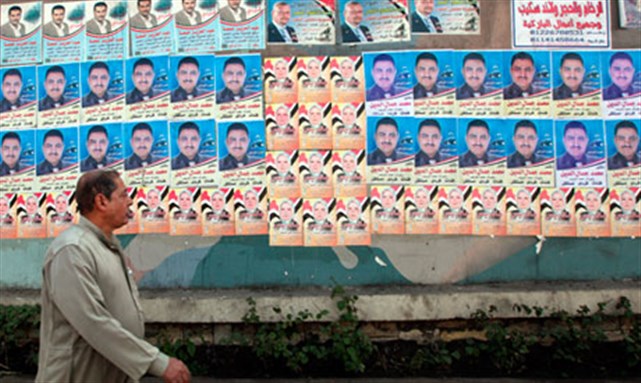 [A man walks past electoral posters in Giza on the outskirts of Cairo. Photo from AP.]