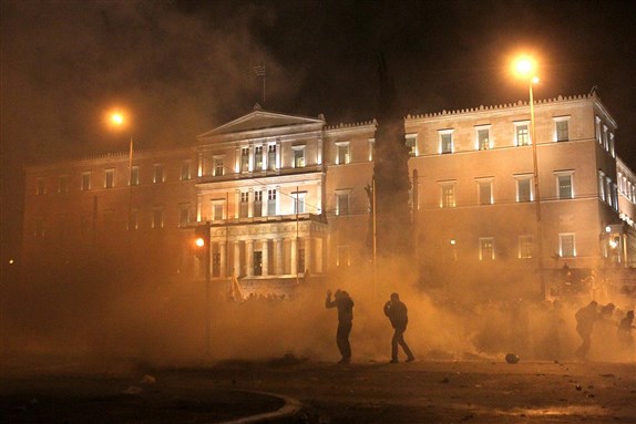 [Riot police use tear gas as protesters stand in front of the Greek Parliament in Athens, Sunday, 12 February 2012. Image by Petros Giannakouris.]