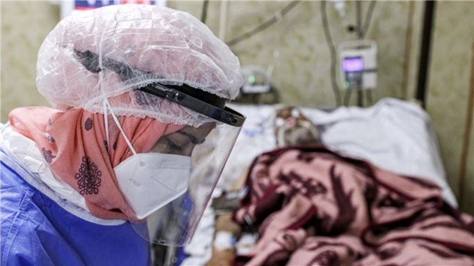 A medic attends to patients at a ward in a hospital dedicated to Covid-19 cases in Syria's rebel-held northwestern city of Idlib on 20 September 2021. (AFP) 