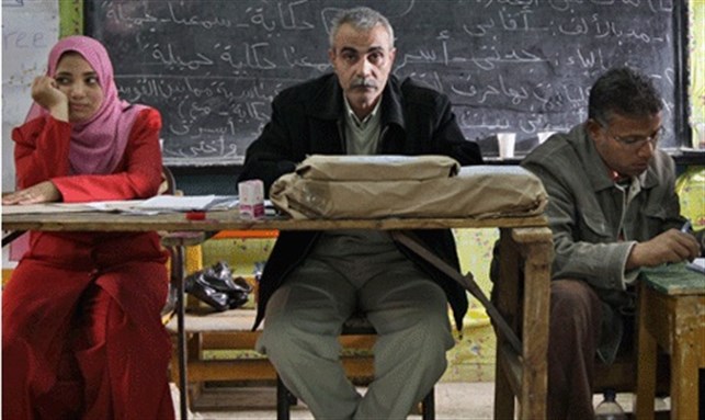 [Election officials wait for voters to arrive to cast their votes for the parliamentary election, which is expected to have a customarily low turnout, in Cairo, Egypt, Sunday, Nov. 28, 2010. Image from AP]