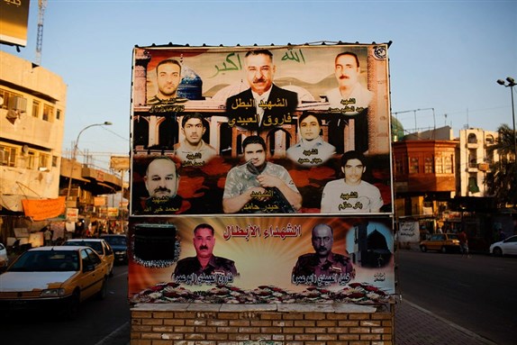 [A mural in A`dhamiyya`s main square depicting many slain Awakening commanders, including Abu Omar, on the bottom right corner. Image by Andrew Henderson]