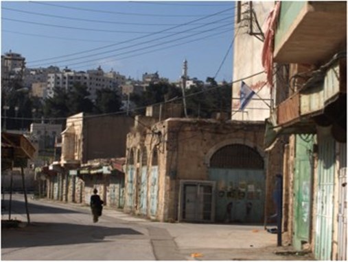 [Walking in the Israeli Settler controlled area in al-Khalil. Image by Isis Nusair.]