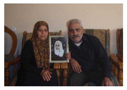 [I’tidal and Ahmed Abu Oda with a picture of their daughter Nariman Abu Oda. Image from pchrgaza.org.]