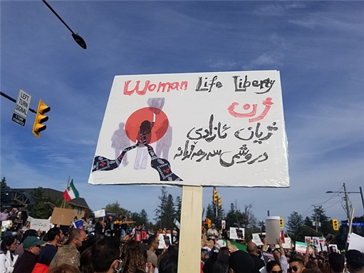 A sign with "Woman, Life, Liberty" (Jin, Jiyan Azadi) on it in Kurdish and English. Photo by Pirehelokan via Wikimedia Commons.
