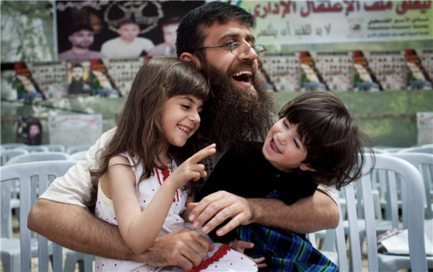 Khader Adnan plays with his daughters in the village of Arraba, near Jenin, after he was released from prison in April 2012 (Oren Ziv/MEE)