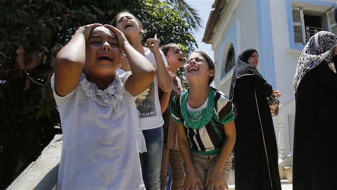 [© AP. Palestinians mourn the death of a family]