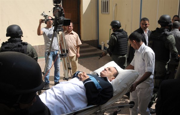 [Mubarak being transported for one of his court appearances. Image from rssbroacast.com]