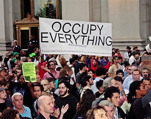 [Protesters march through the financial district in New York. Photo by David Shankbone from Wikimedia Commons]