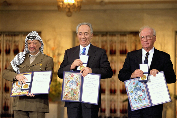 Yitzhak Rabin, Shimon Peres and Yasser Arafat receiving the Nobel Peace Prize following the Oslo Accords (1994). Photo via Wikimedia Commons.