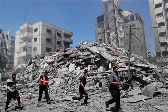 People inspect the rubble of a residential building that was destroyed by an Israeli airstrike in Gaza City on Sunday via AP by Adel Hana