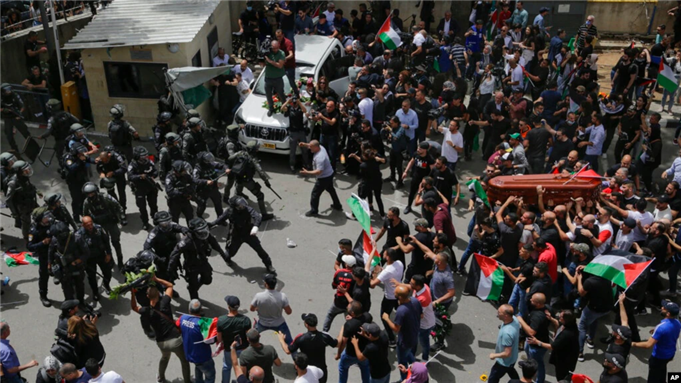 Israeli police confront mourners carrying the casket of slain Al Jazeera journalist Shireen Abu Akleh during her funeral in east Jerusalem, May 13, 2022. Photo by Voice of America.
