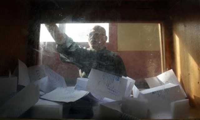 [A man casts his vote during the first day of the parliamentary run-off elections at a polling station in Cairo. Photo credit: Reuters.]