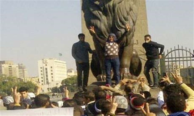 [Samira Ibrahim, who has become another revolutionary icon, makes victory signs while celebrating with her supporters. Photo credit: Ahram.]