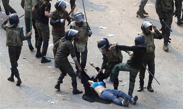 [Egyptian army soldiers arrest a female protester during clashes at Tahrir Square in Cairo. Photo credit: Reuters.]